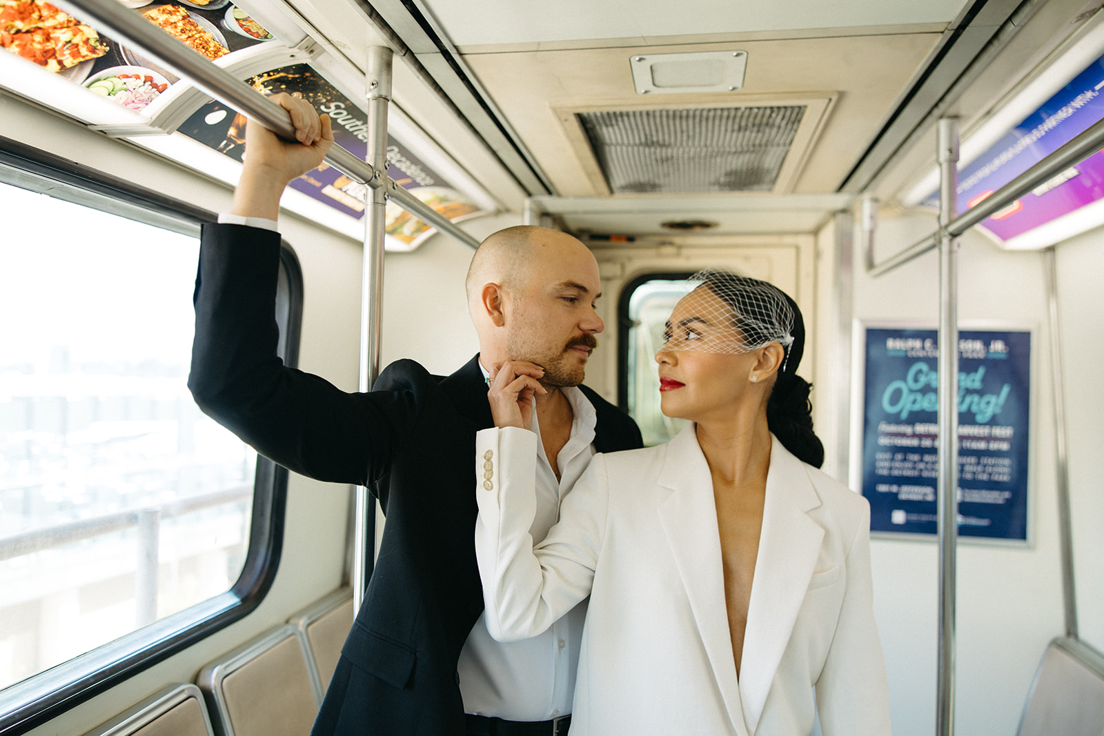 Couple posing on the People Mover during their editorial Detroit elopement photos. 