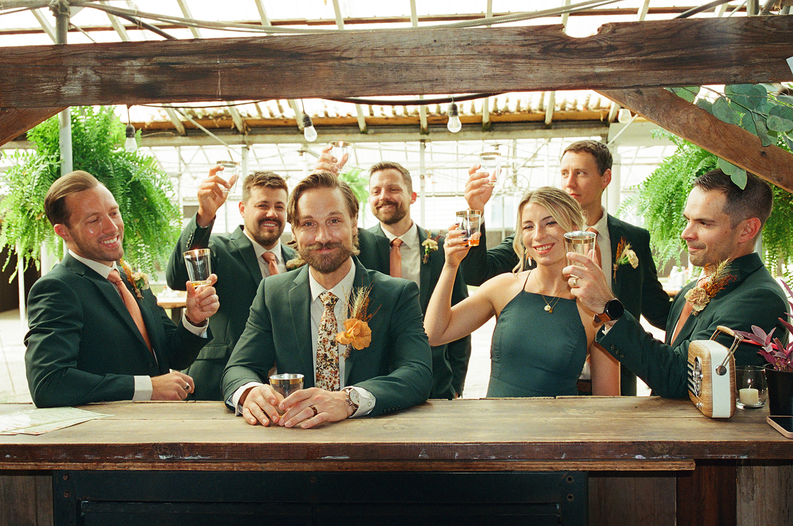 Groom and friends toasting with drinks captured on film.
