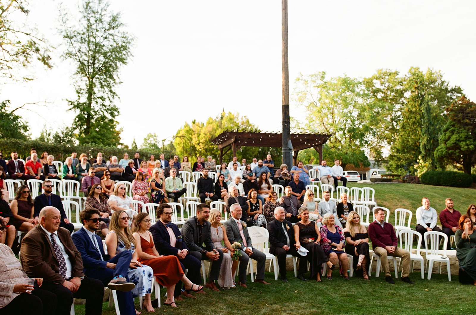 Guests sitting in lawn chairs as they wait for a Michigan wedding ceremony to begin captured on film.