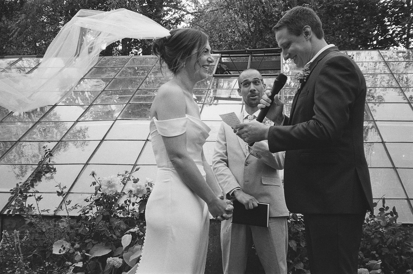 Black and white photo of a couple exchanging vows during their Michigan wedding on film.