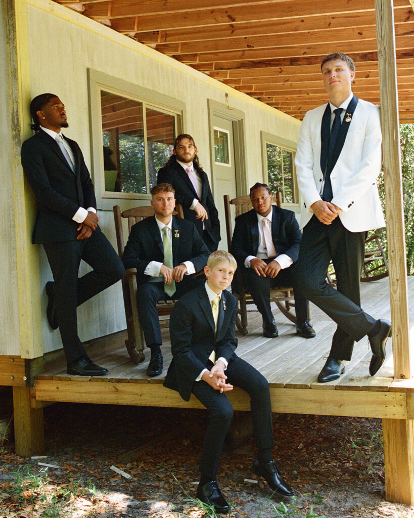 Groom and his groomsmen posing on a deck captured on film.