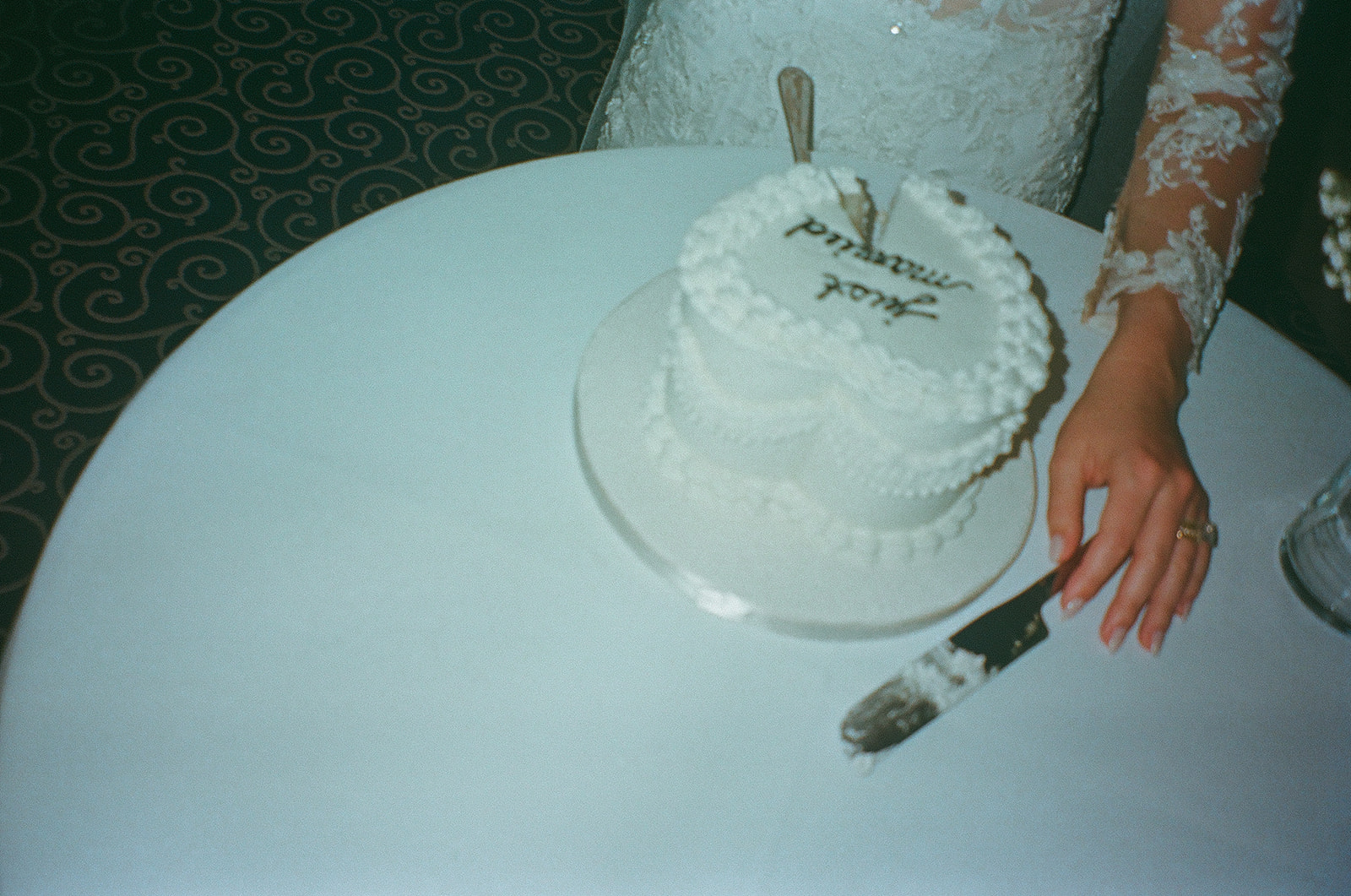 Film wedding photo of a couple after cutting into their wedding cake.