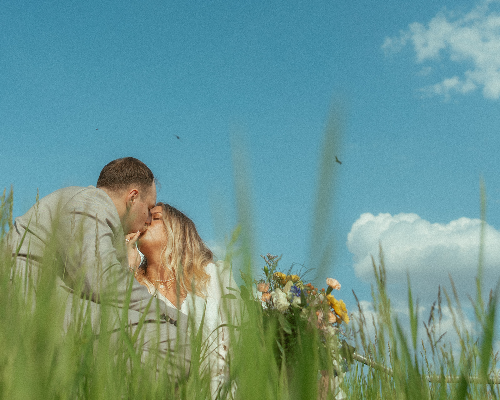 Bride and groom posing in the grass during their Michigan elopement photos,.