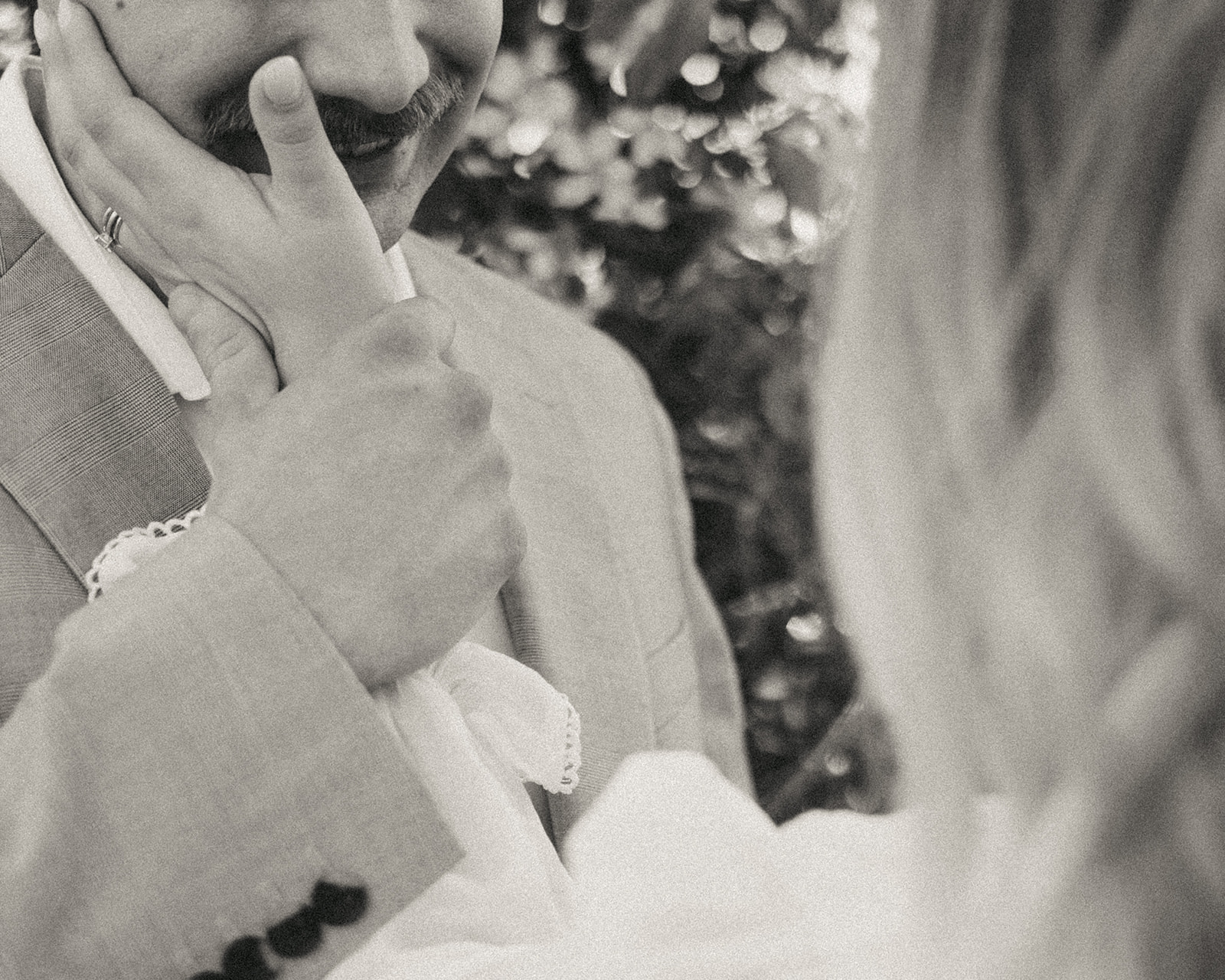 Close up black and white photo of a woman caressing her husbands face during their Michigan elopement photo session.