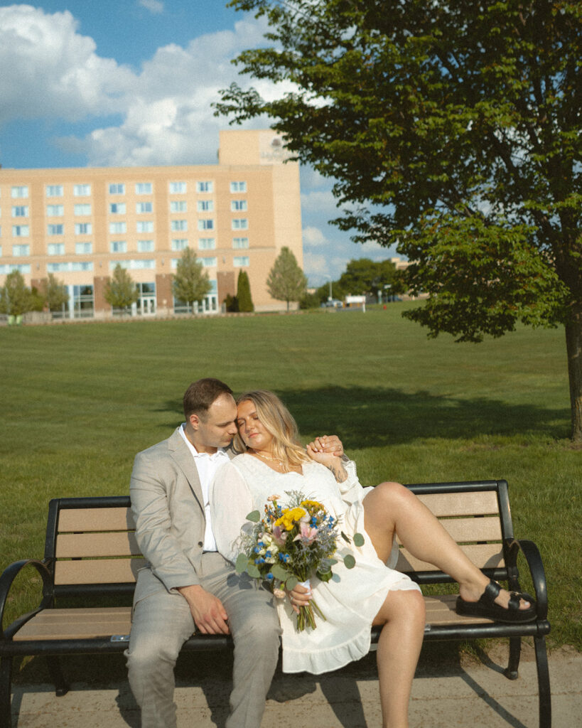 Couple sitting on a park bench together for their Michigan elopement photos in Bay City.