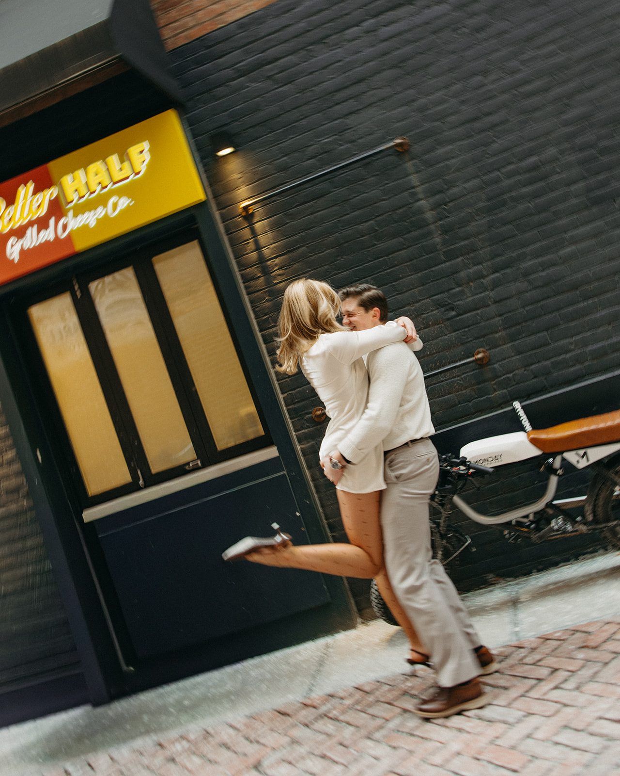 Couple posing for their downtown Detroit engagement photos in front of Better Half Grilled Cheese Co.