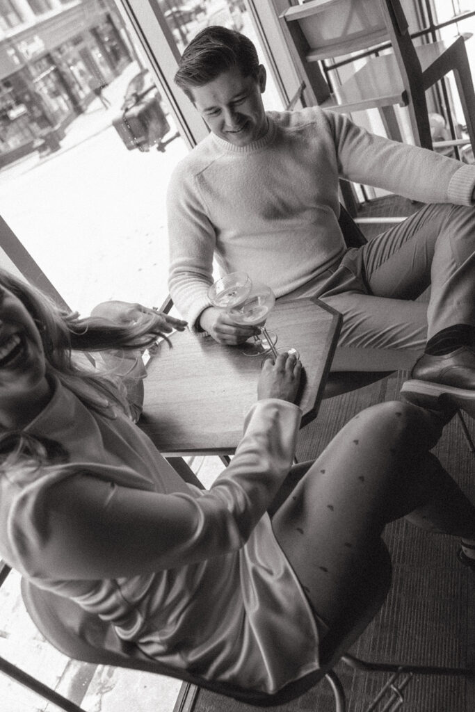 Black and white photo of a couple having drinks as they sit at a table in downtown Detroit.