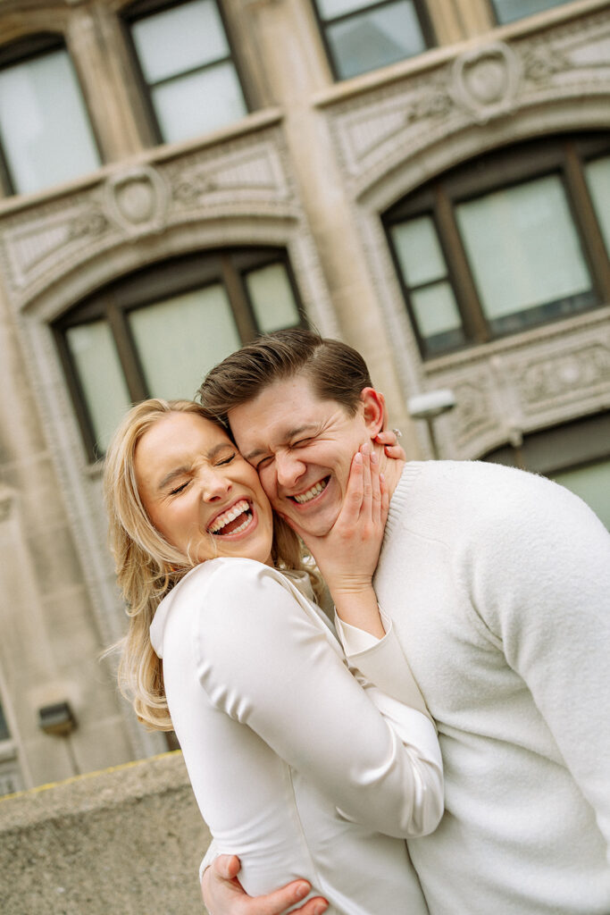 Close up of a couple smiling and laughing during their downtown Detroit engagement photos.
