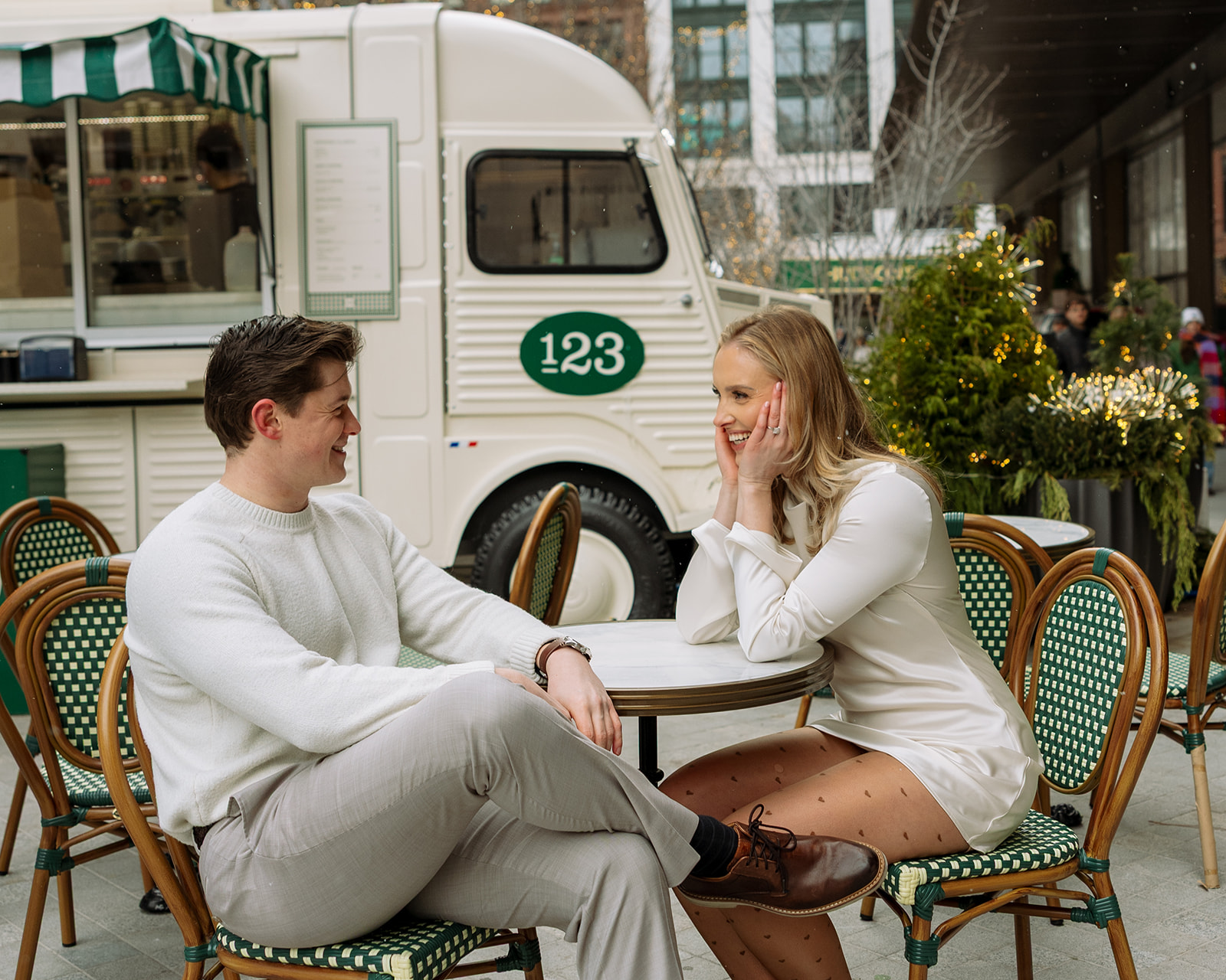 Couple sitting at café tables outside Un Deux Trois at Hudson’s Detroit.
