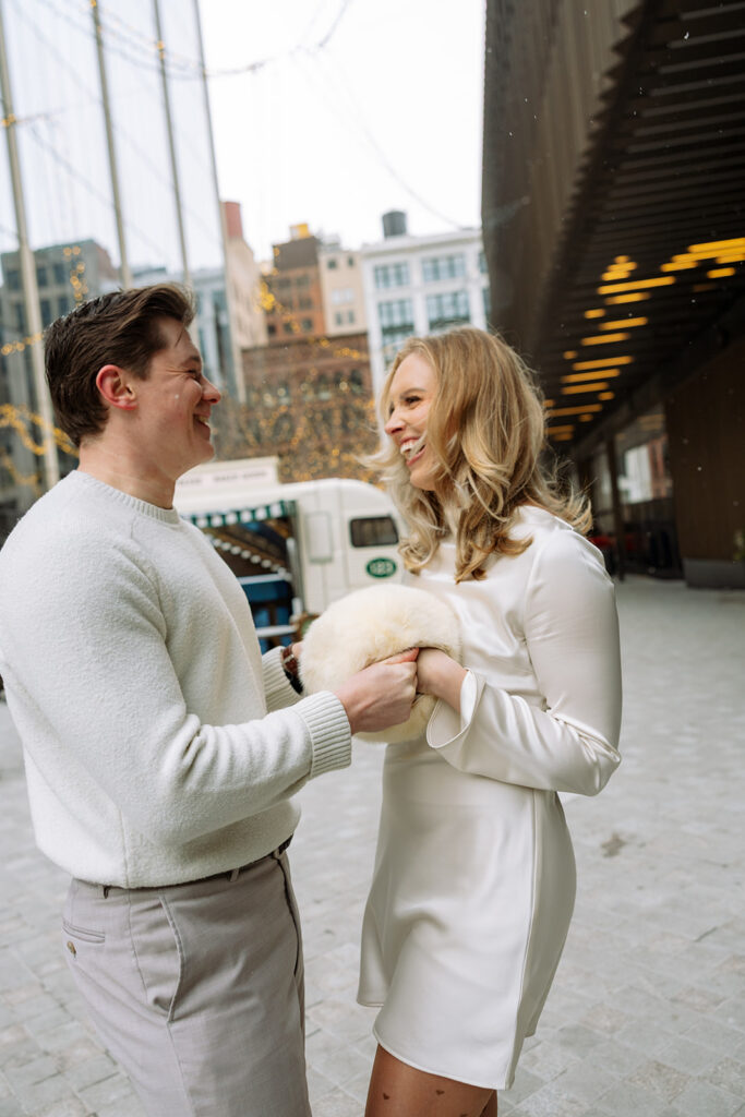 Couple holding hands and laughing near the Un Deux Trois café truck in downtown Detroit.