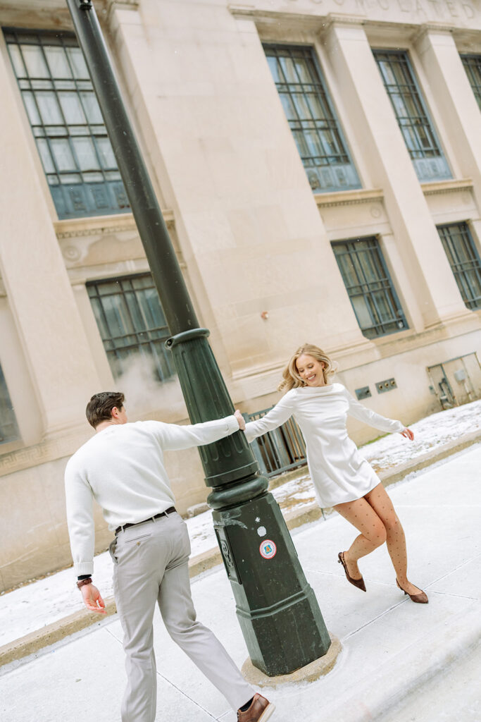 Couple spinning together by a streetlight in downtown Detroit during winter.