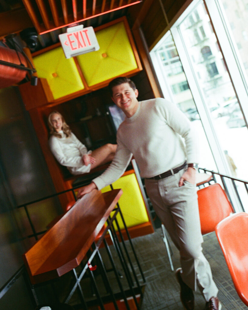 Couple posing inside a colorful space at SPKRBX in Detroit for their engagement photos, captured on film.