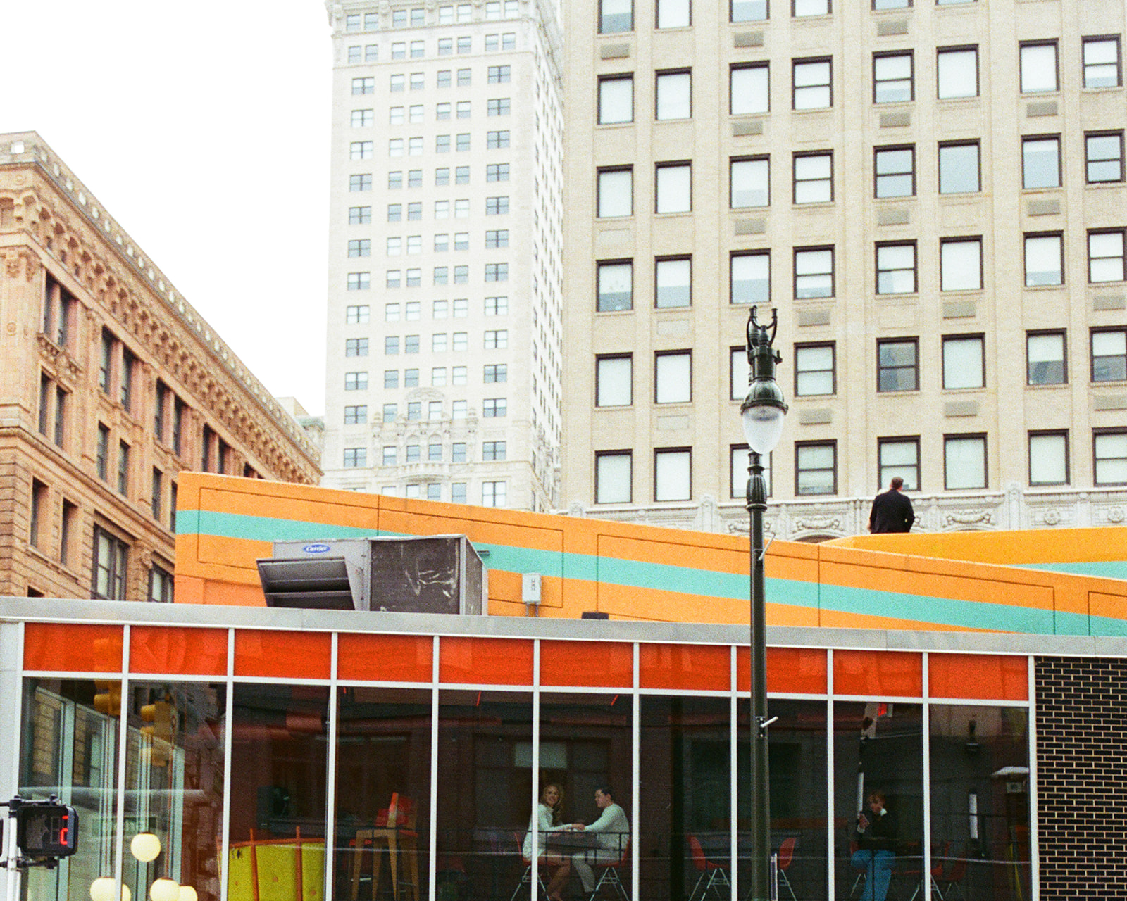 Exterior view of couple sitting inside SPKRBX in downtown Detroit space, photographed on 35mm film.