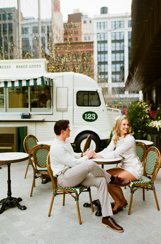 Couple at outdoor café seating near a food truck in downtown Detroit, photographed on film.