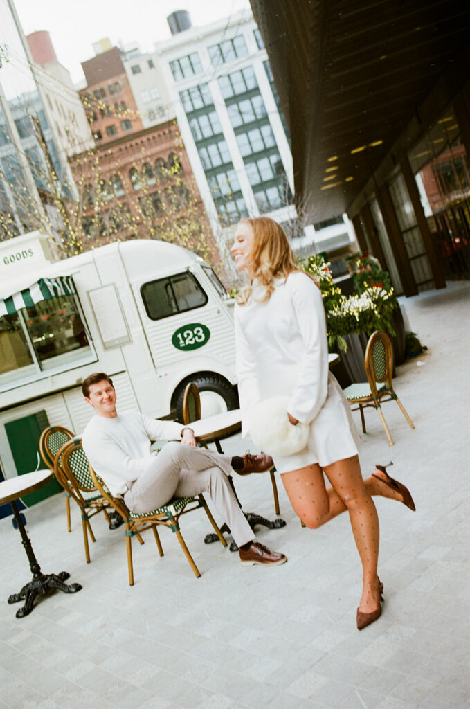Couple at outdoor café seating near a food truck in downtown Detroit, photographed on film.