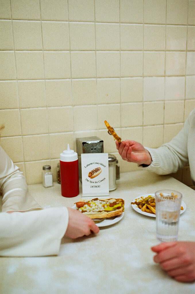 Close up shot of a couple sitting inside Lafayette Coney Island, photographed on film.