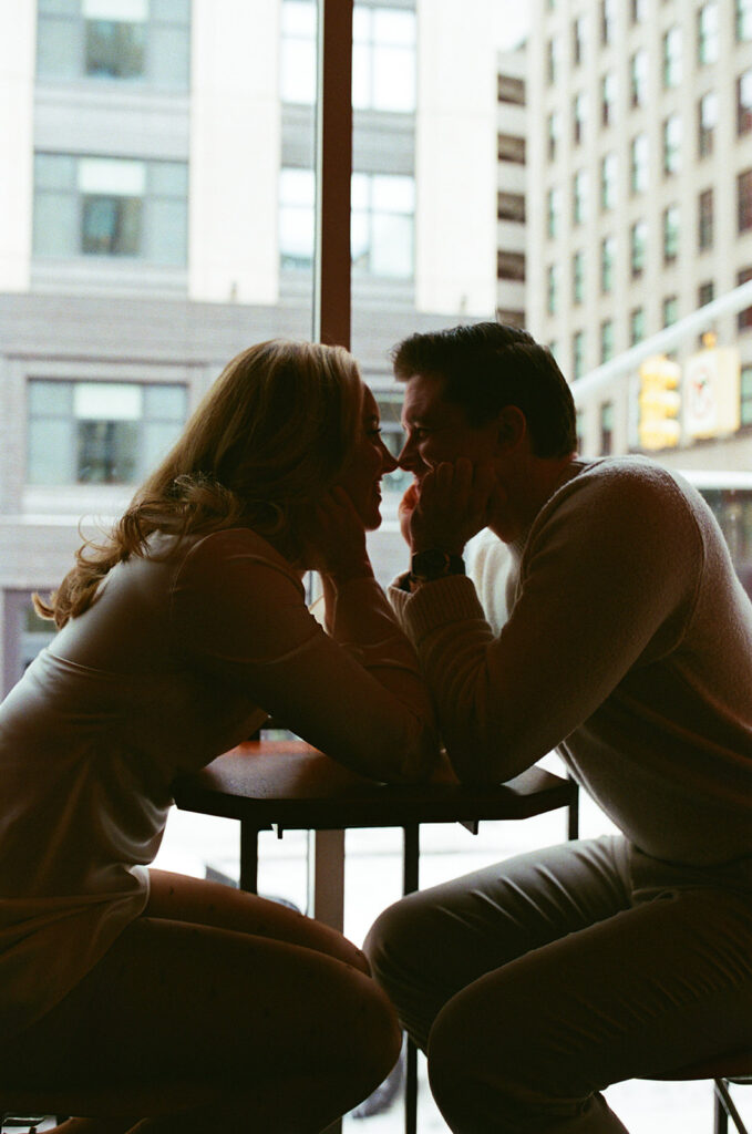 Couple sitting across from each other at a window table in downtown Detroit, photographed on film.