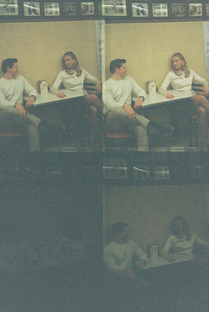 Film scan of couple sitting inside Lafayette Coney Island in downtown Detroit with light leaks.