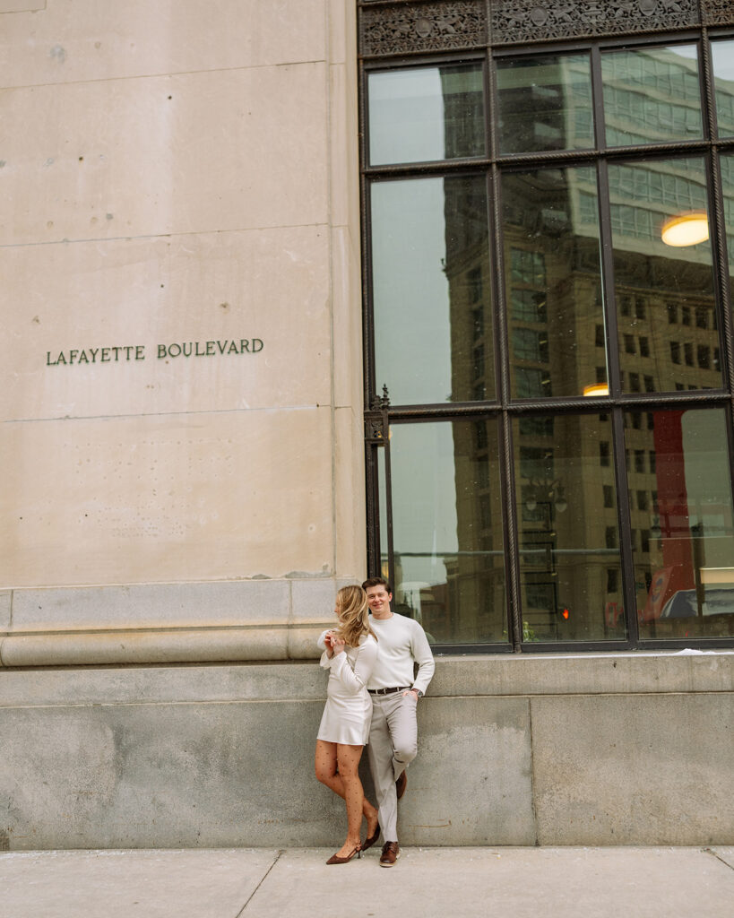 Couple posing for photos on Lafayette Boulevard for their Detroit engagement photos downtown.
