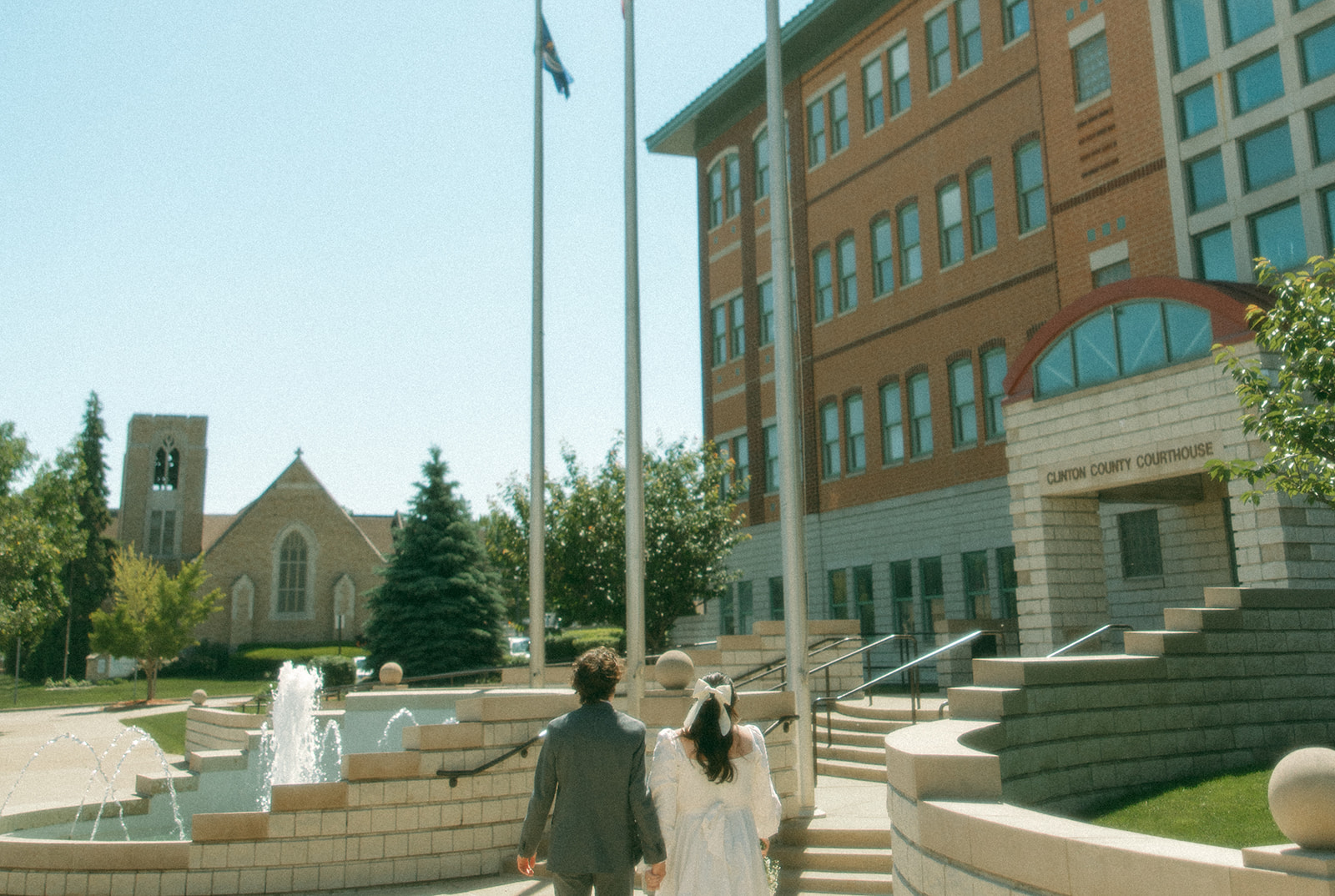 Couple walking outside of Clinton County Courthouse for their intimate Michigan courthouse wedding.