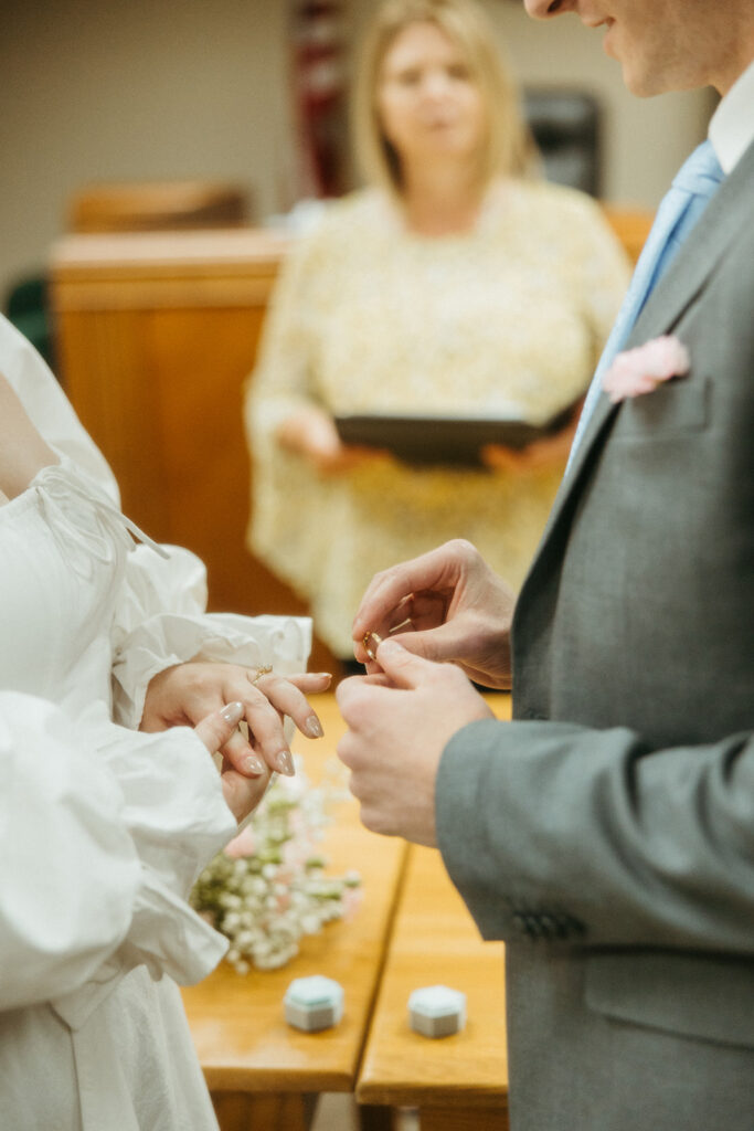 Couple exchanging rings during their Michigan courthouse wedding.