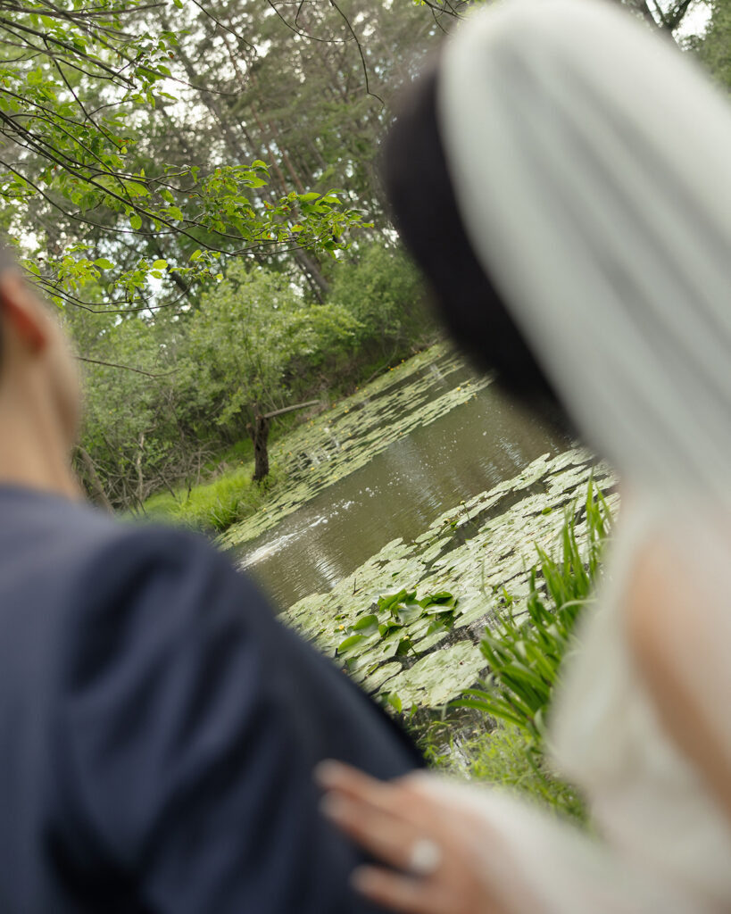 Bride and groom posing by a lake for their Michigan micro wedding ceremony.