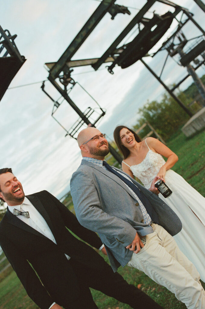 Documentary Michigan wedding photo of a couple laughing with a friend outdoors. 