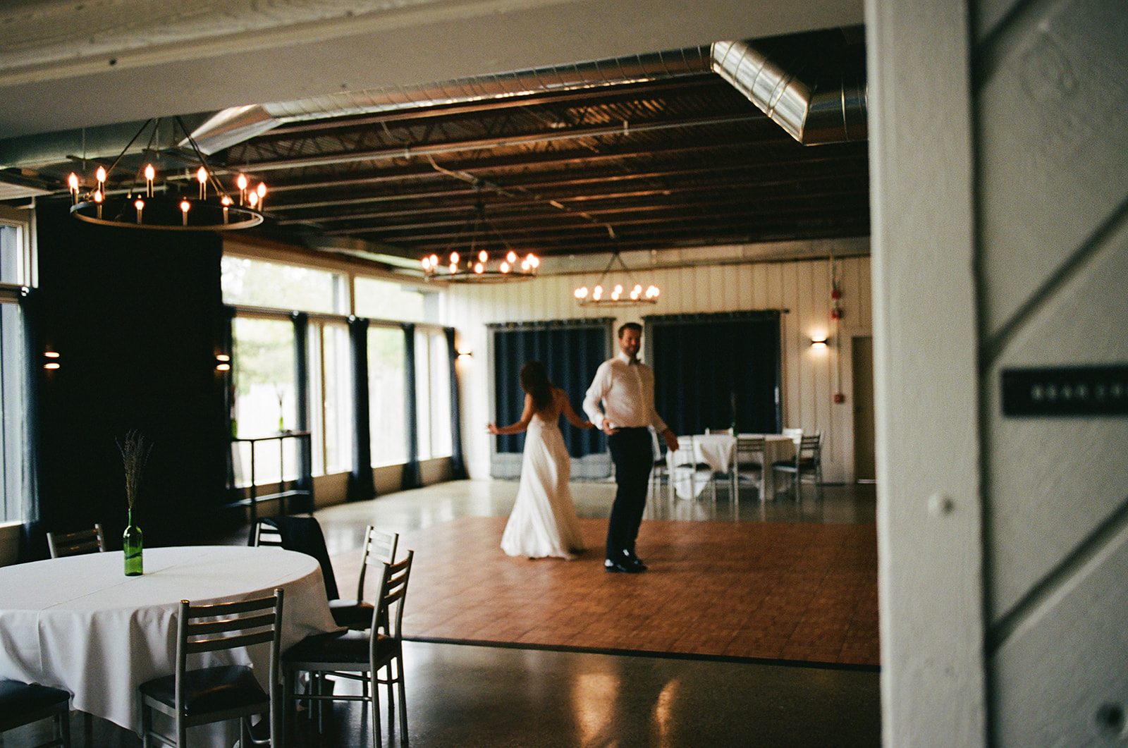 Bride and groom spinning and laughing together during a private first dance.