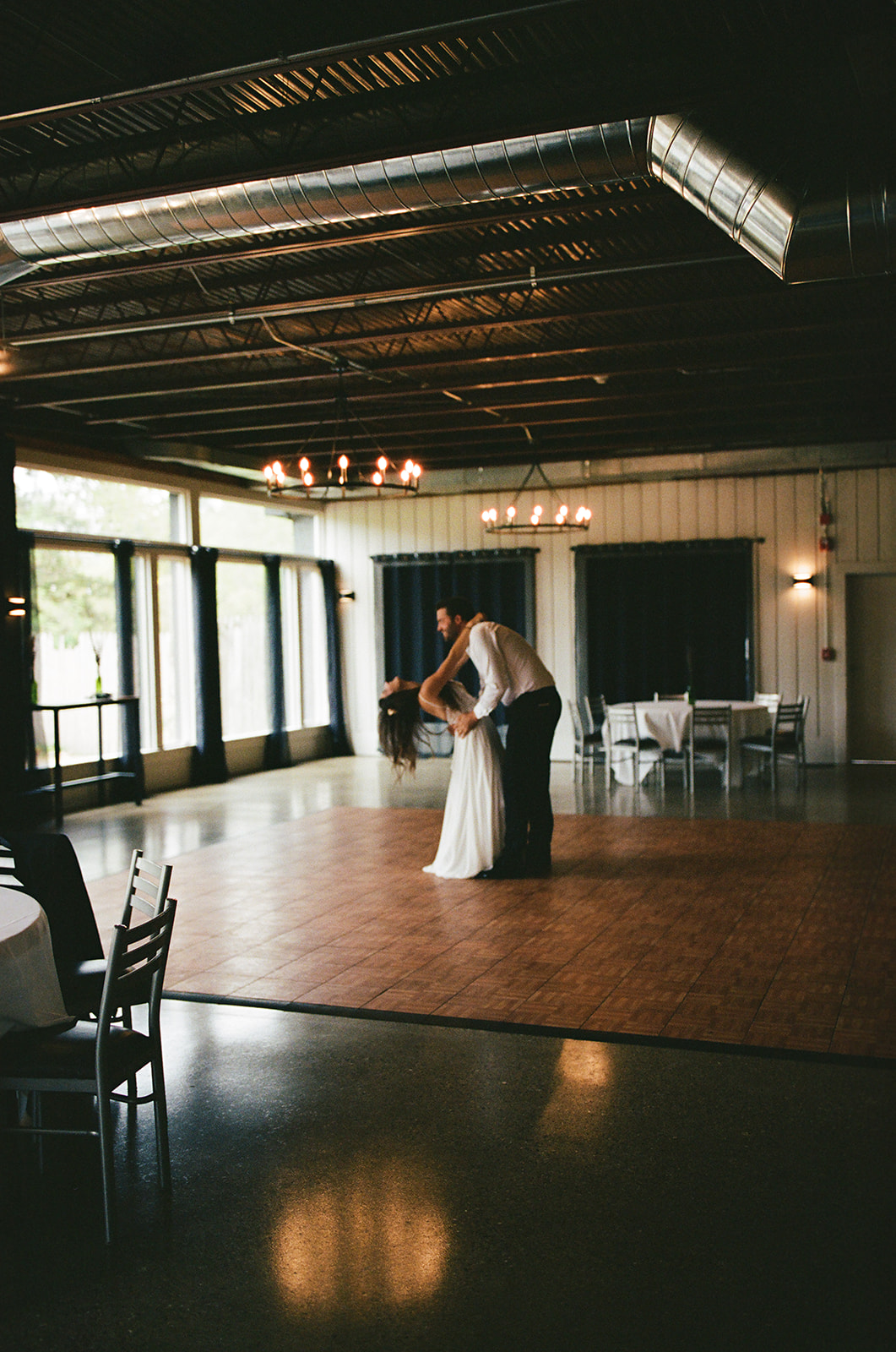 Bride and groom sharing a quiet first dance on film in an empty reception space at a documentary Michigan wedding near Grand Rapids.