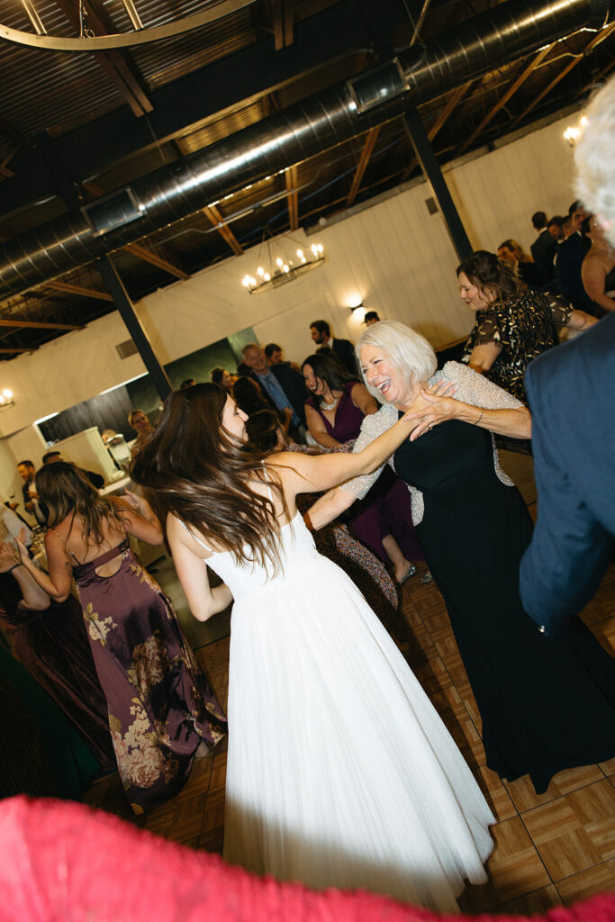 Bride dancing with a guest during her documentary Michigan wedding reception.