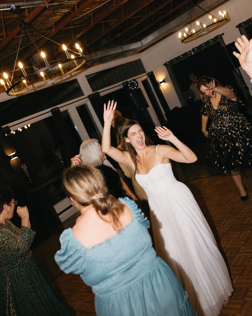Bride dancing on the dance floor with guests.