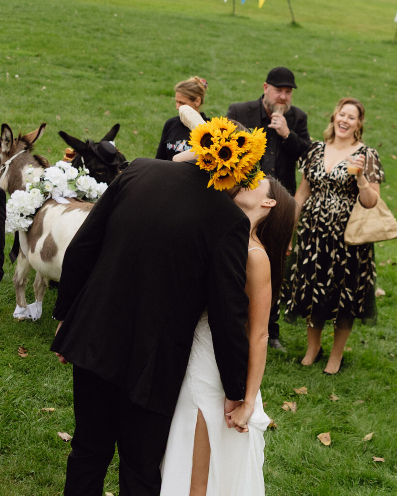 Candid photo of a bride and groom kissing outdoors. 