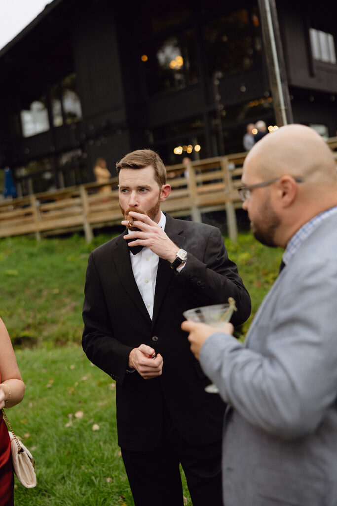 Guests smoking and drinking as they mingle outdoors. 