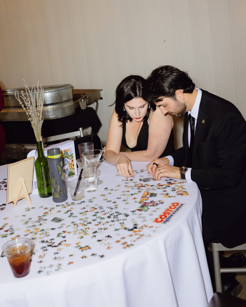 Guests working on a puzzle together at a reception table during a documentary michigan wedding near grand rapids.