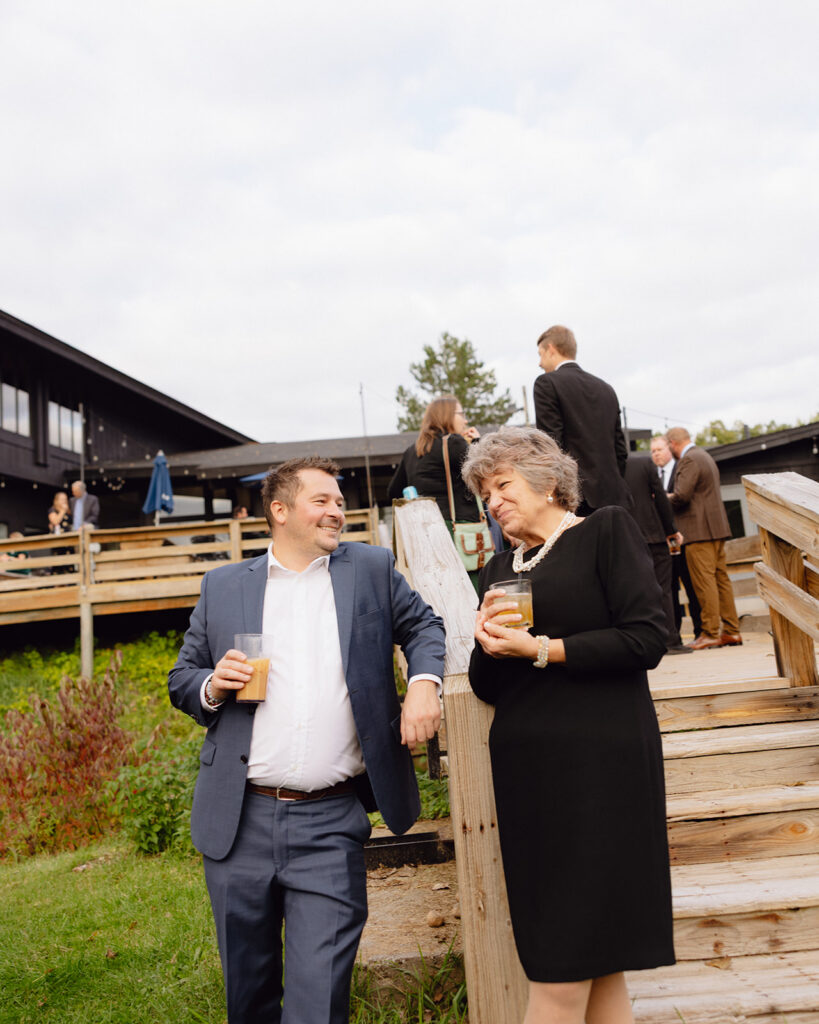 Two guests mingling together while holding drinks. 