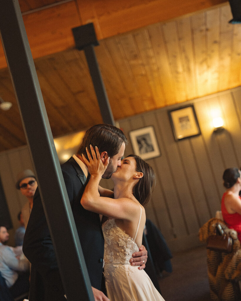 Bride and groom kissing after giving a speech during their Michigan wedding reception captured in a documentary style.