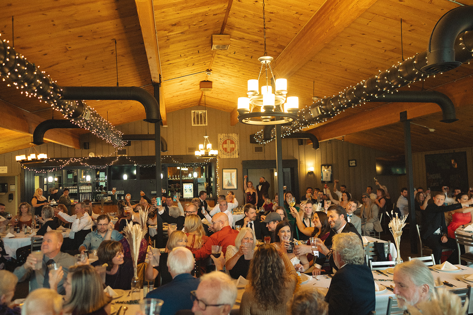 Candid photo of guests enjoying dinner during a Michigan wedding reception near Grand Rapids. 