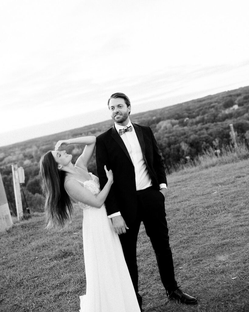 Black and white photo of a bride and groom standing outdoors together during their documentary Michigan wedding photos. 