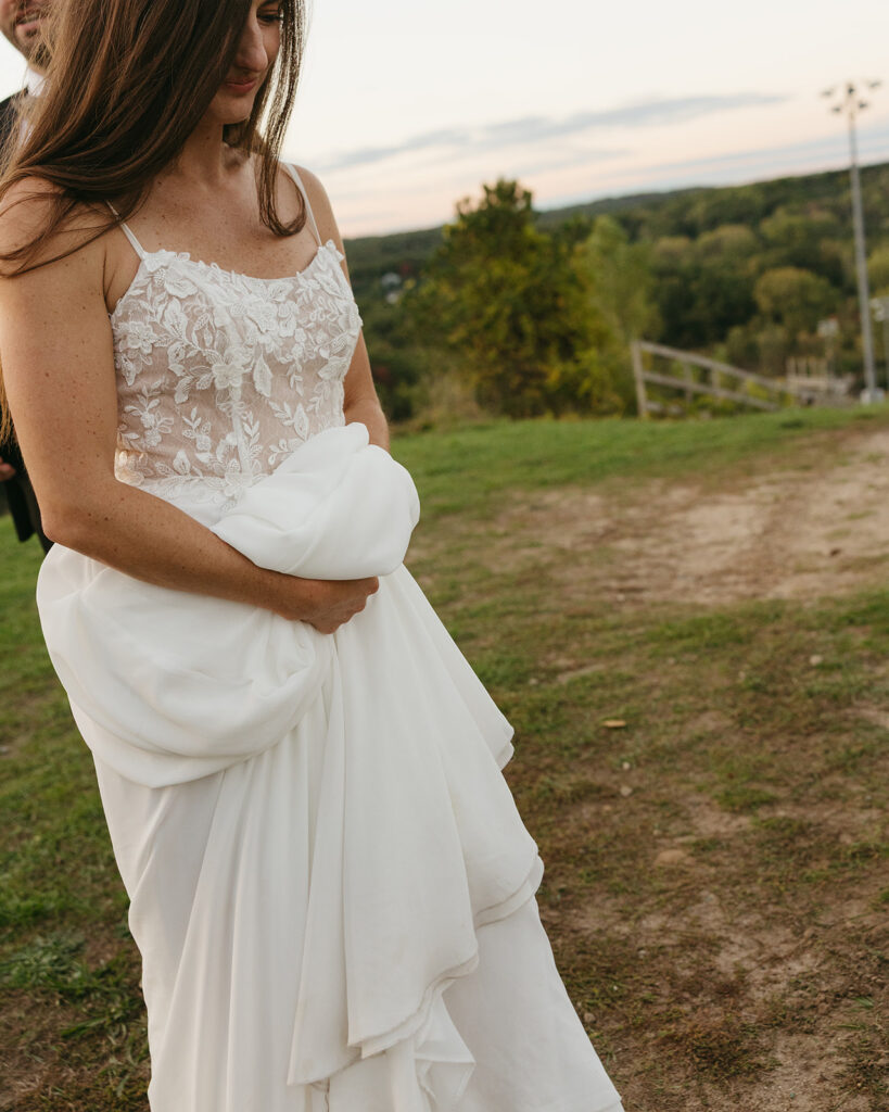 Close up photo of a bride and groom walking together outdoors.