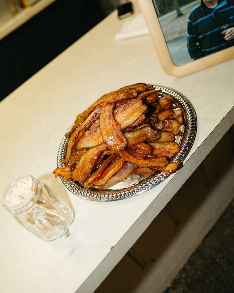 A pile of bacon on a plate at the bar.