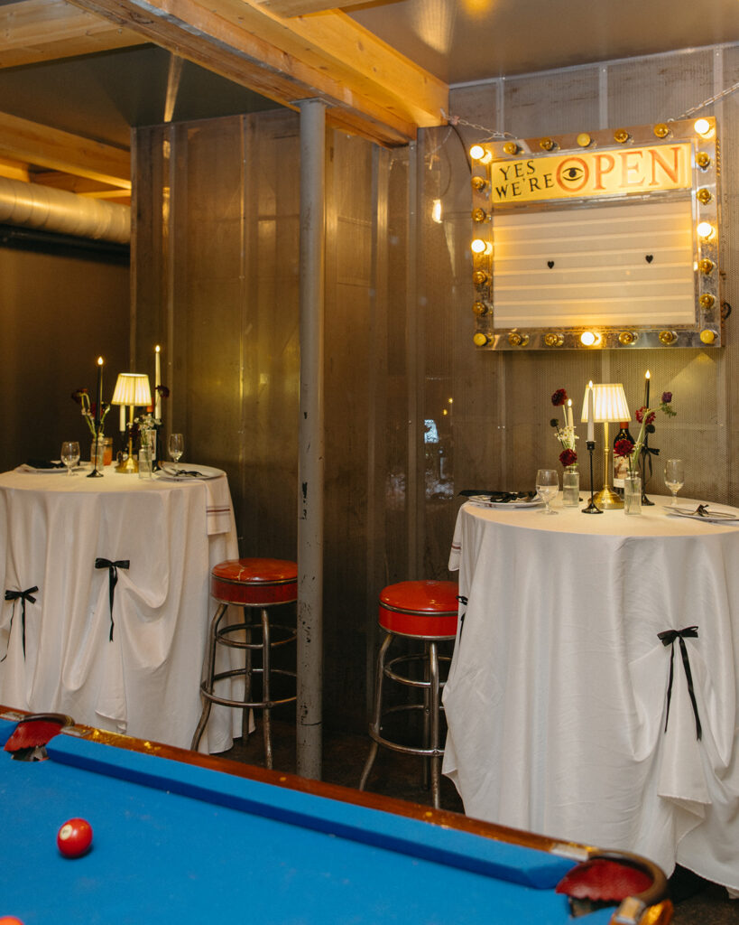Cocktail tables with candles and signage at Unionwood Shop Clarkston Michigan wedding.