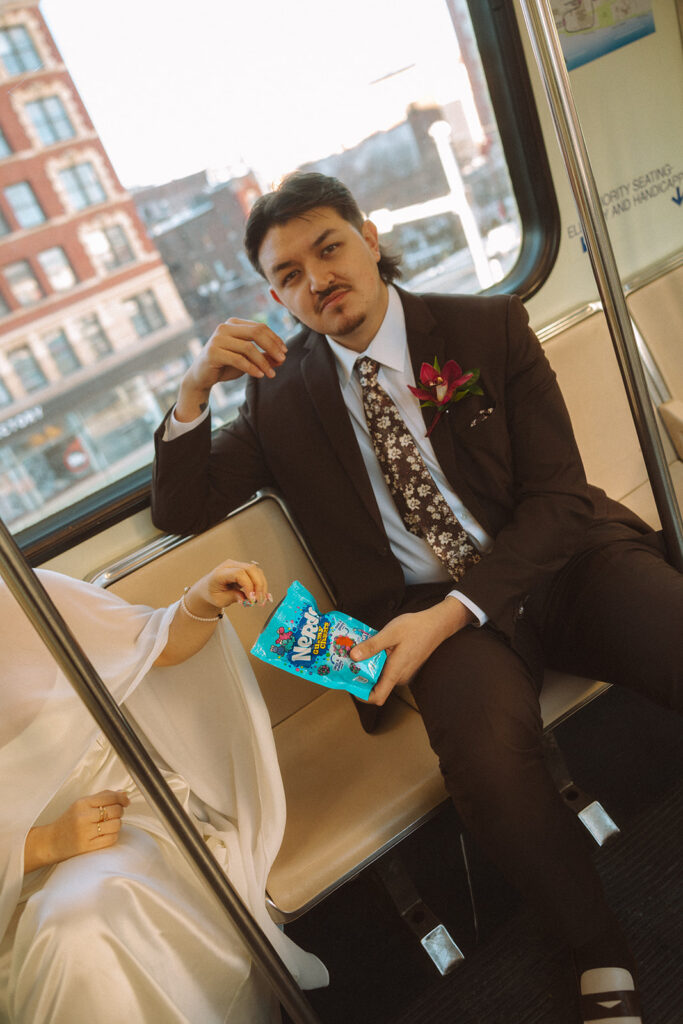 Bride and groom sharing Nerd Clusters candy on Detroit People Mover during downtown Detroit elopement.