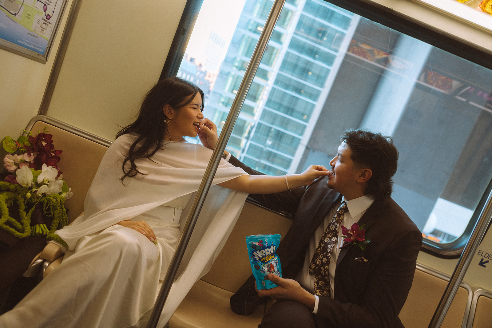 Couple sharing candy on the Detroit People Mover for their downtown elopement photos.