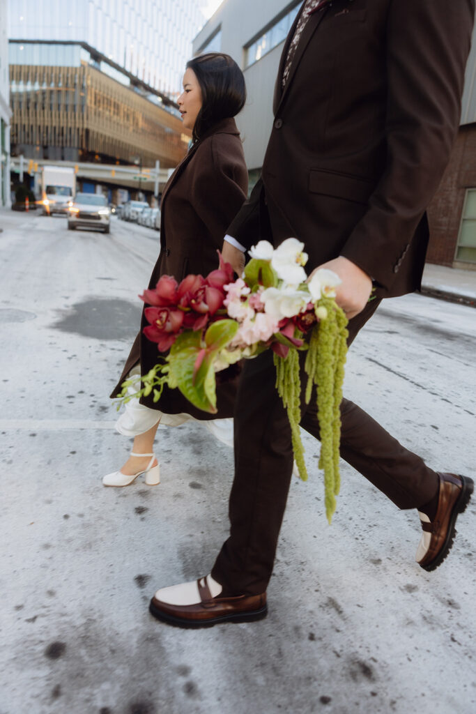 Bride and groom walking across a street during their Downtown Detroit elopement.