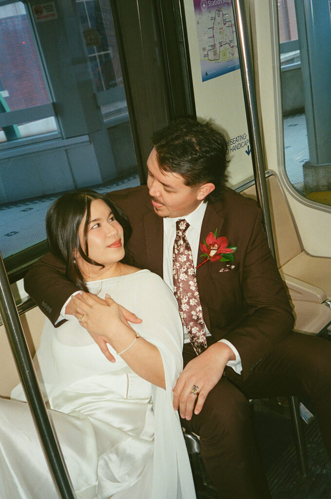 Bride and groom snuggled close together as they ride the Detroit People Mover captured on film.