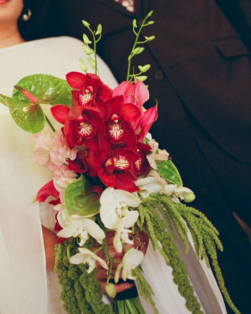 Bride holding colorful bouquet during Fisher Building elopement film photo with soft grain and motion.