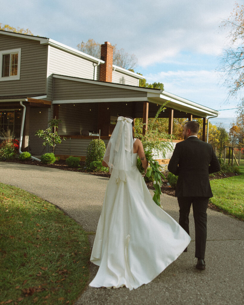 Bride and groom walking back up to their home.