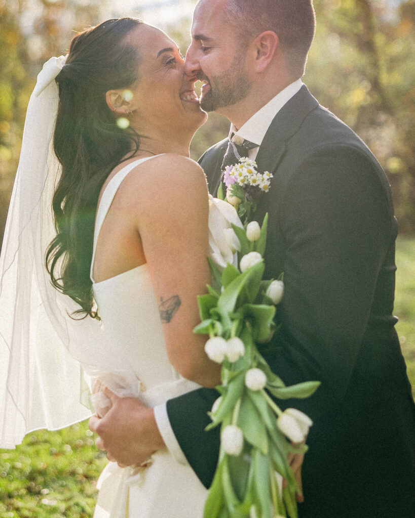 Bride and groom laughing while hugging during their first look.