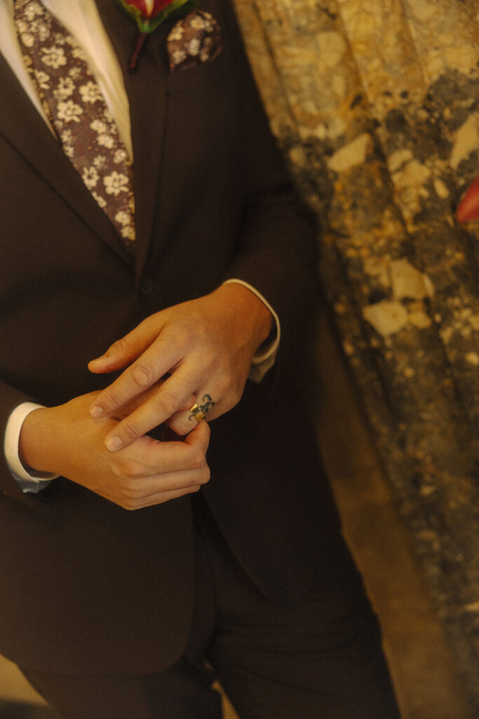 Close up shot of a groom adjusting his wedding ring.