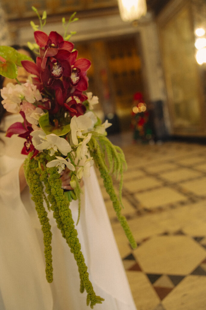 Bride holding bouquet in flowing dress.